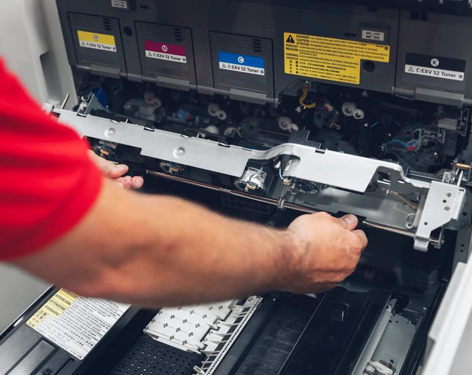 Tecnico al lavoro su una stampante professionale