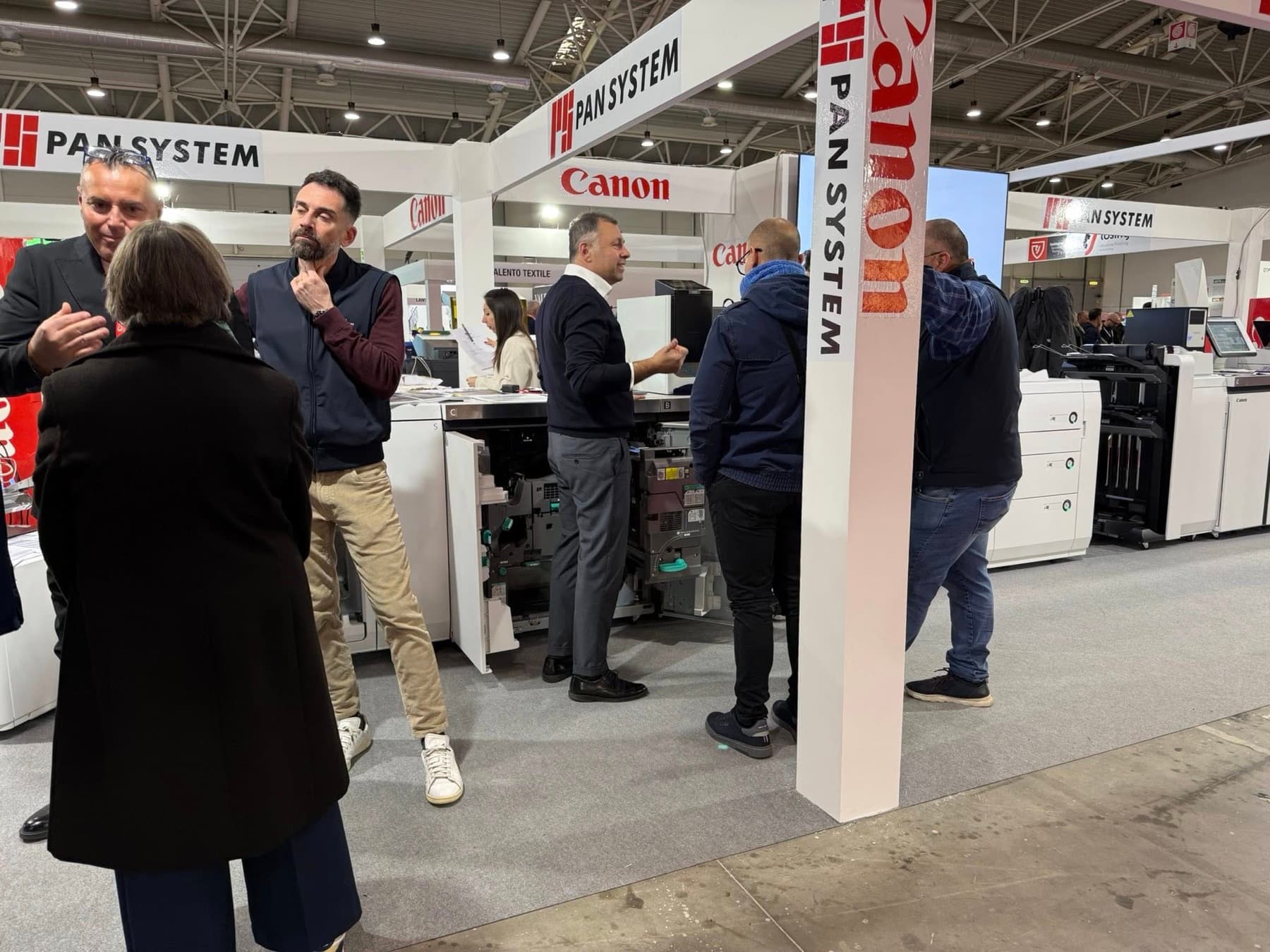Visitatori e consulenti Pan System davanti a una Canon imagePRESS aperta
