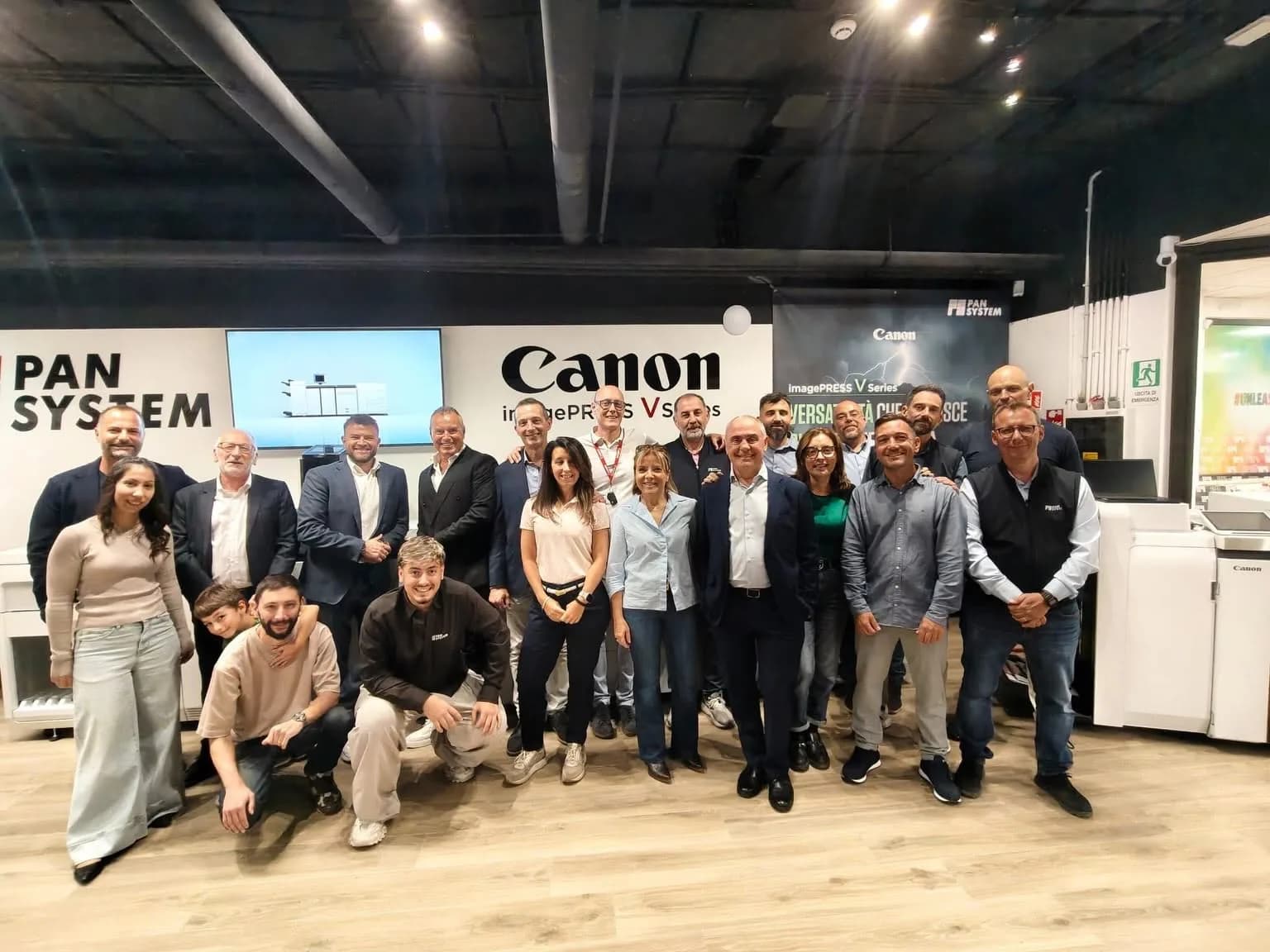 Foto di gruppo nel Pan System Experience Center davanti all’area Canon