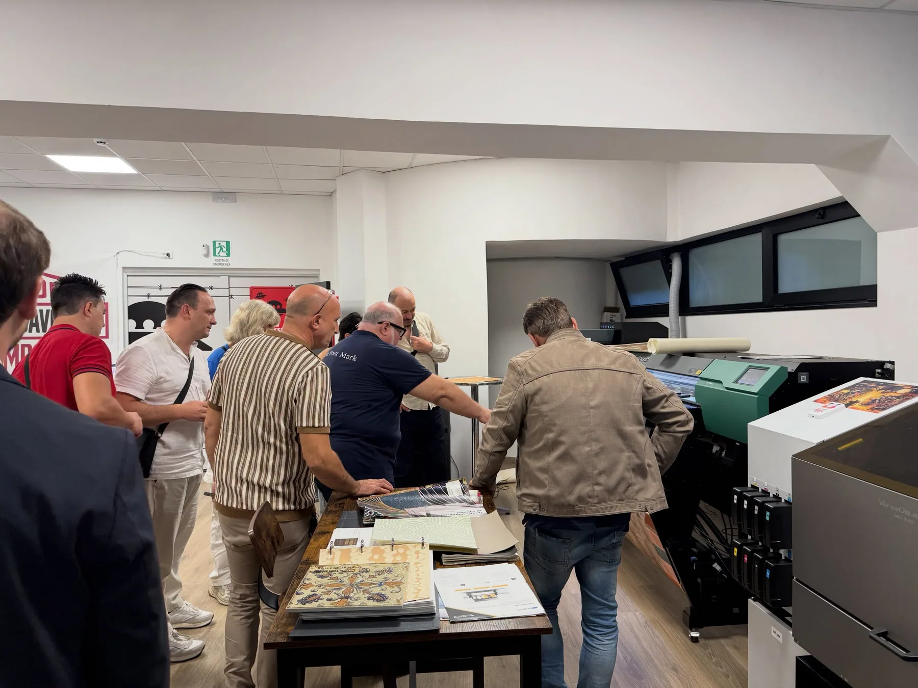 Partecipanti riuniti intorno a una macchina nell’Experience Center