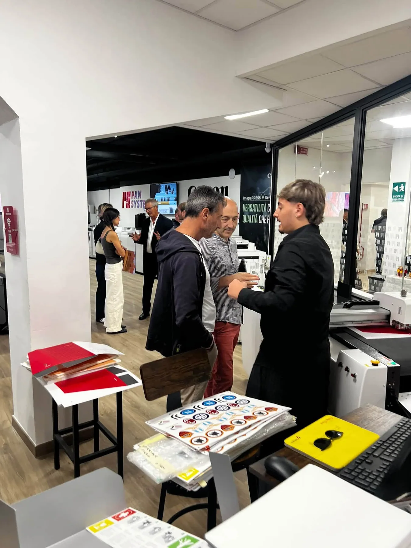 Due partecipanti si confrontano tra macchine e campioni di stampa