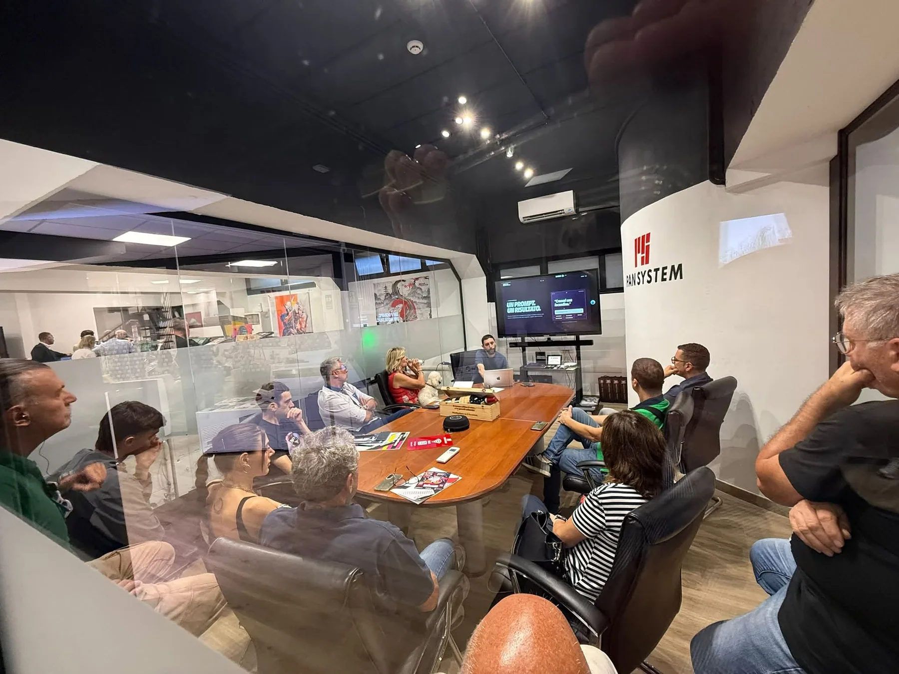 Partecipanti seduti intorno al tavolo nella sala workshop del Pan System Experience Center